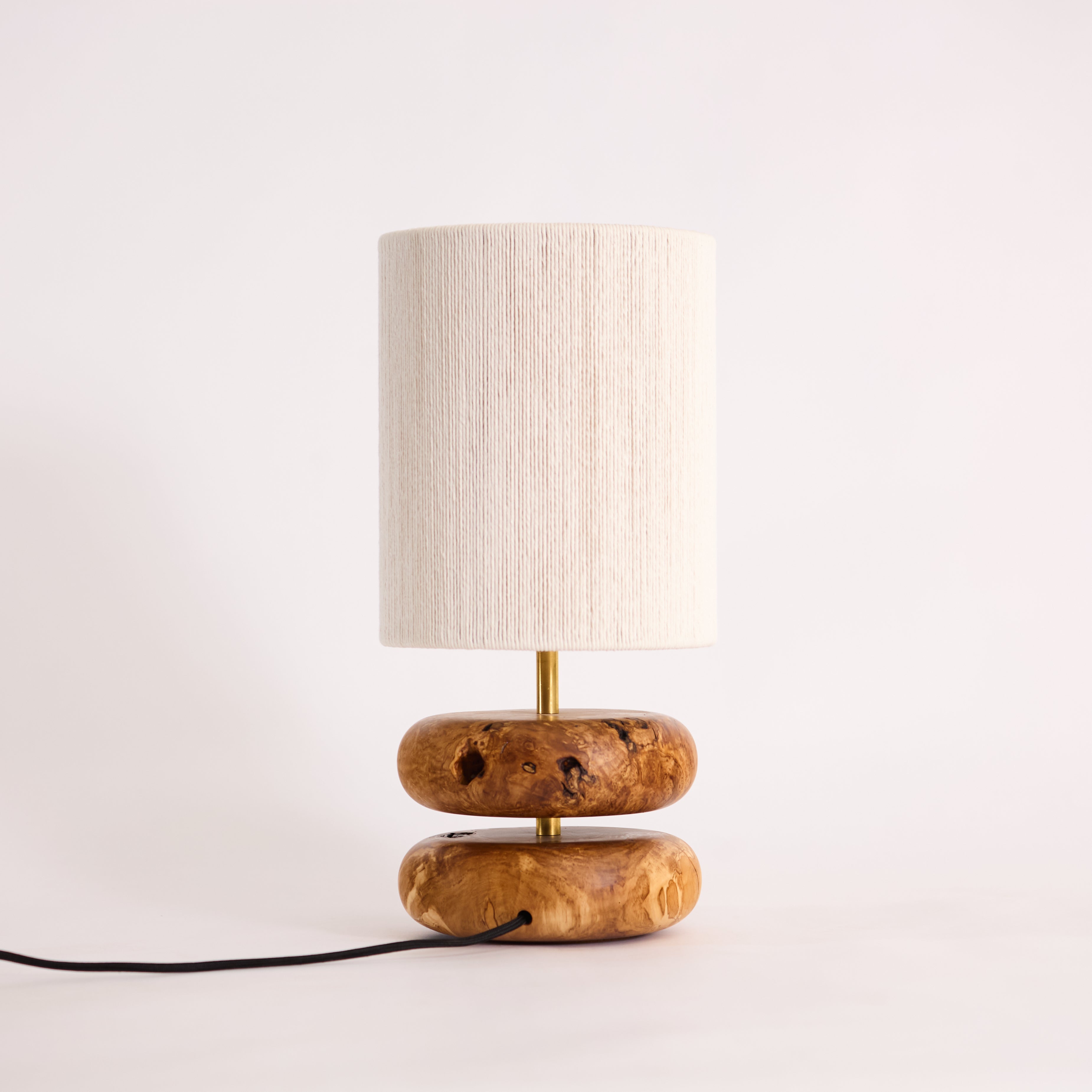 Table lamp with wooden base and white lampshade on a light background